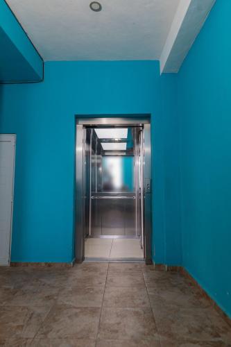 an elevator in an empty room with blue walls at Hotel Las Palmas en Laurel in Cancún