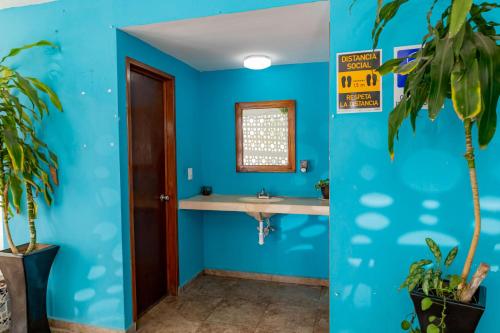 Baño azul con lavabo y espejo en Hotel Laurel Cancún Centro en Cancún