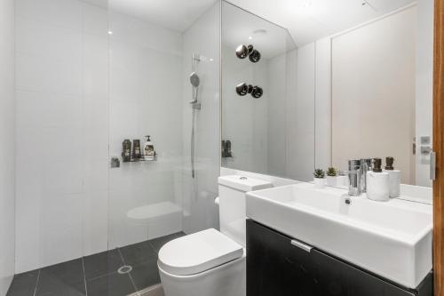 een witte badkamer met een toilet en een wastafel bij Cozy & Romantic 1 Bedroom Apt in Southbank with Pool & Gym in Melbourne