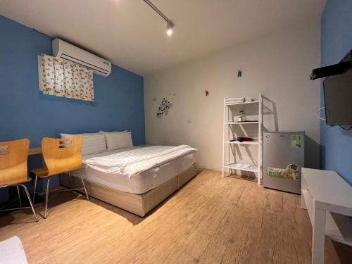 1 dormitorio con 1 cama, mesa y sillas en Lazy bone, en Hsinchu City