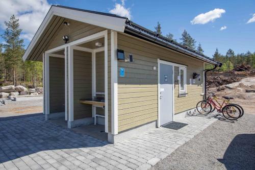un pequeño edificio con una bicicleta estacionada frente a él en Luxury tent - Villmarkseventyret, en Håtvet