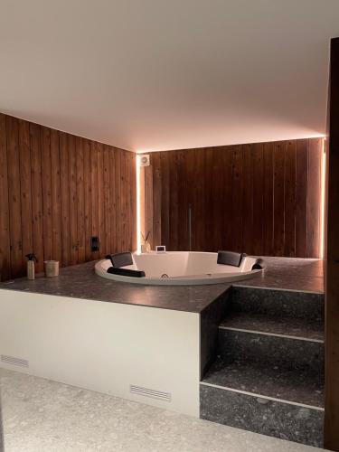 a bath tub in a room with wooden walls at Maison Ensor - Lux Living in De Panne
