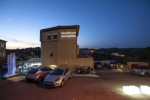 a parking lot with cars parked in front of a building at Porta Pispini Residence in Siena