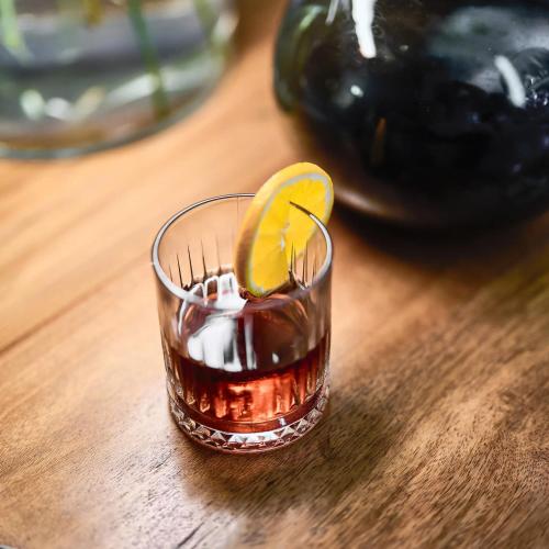 a glass of tea with an orange on a wooden table at Bambarone La Masseria in Fasano