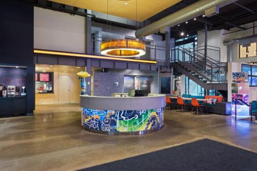 a lobby with a bar with graffiti on it at Aloft Birmingham Soho Square in Homewood