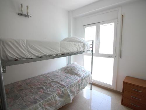 罗萨斯Apartamento Roses, 2 dormitorios, 4 personas - ES-228-152的卧室设有一张双层床,位于窗户旁