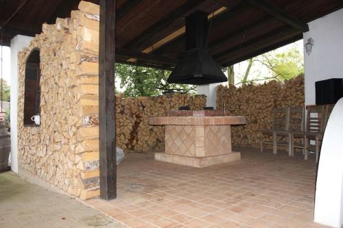 a stone fireplace in a patio with a stone wall at Quiet and charming log farmhouse in Libošovice