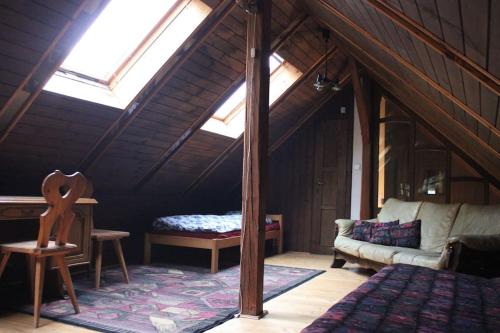 een kamer met een bed en een bank op zolder bij Quiet and charming log farmhouse in Libošovice
