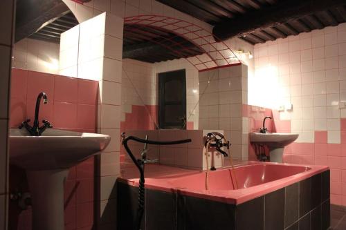een badkamer met een wastafel en een roze bad bij Quiet and charming log farmhouse in Libošovice