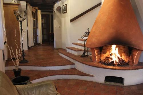 a fireplace in the middle of a room with stairs at Quiet and charming log farmhouse in Libošovice
