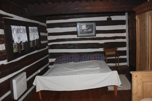 a bedroom with a bed in a wooden room at Quiet and charming log farmhouse in Libošovice