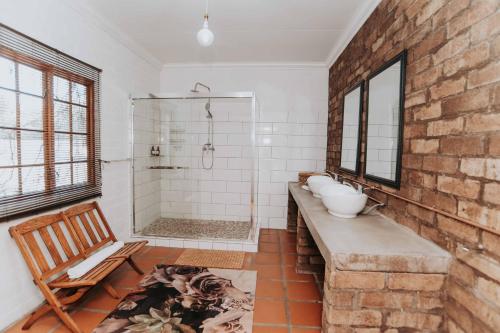 a bathroom with two sinks and a glass shower at Upington African Vineyard Boutique Hotel & SPA in Kanoneiland