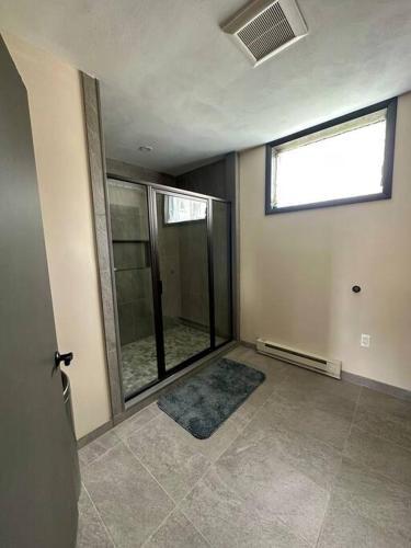 an empty room with a large window and a tiled floor at Cozy 1-Bedroom Suite in Sybertsville