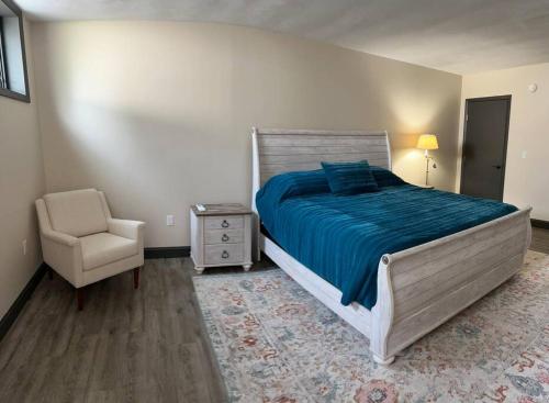 a bedroom with a large bed and a chair at Cozy 1-Bedroom Suite in Sybertsville