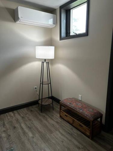 a room with a lamp and a bench and a window at Cozy 1-Bedroom Suite in Sybertsville
