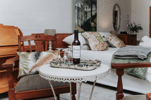 a room with a bed with a table with a bottle of wine at Upington African Vineyard Boutique Hotel & SPA in Kanoneiland