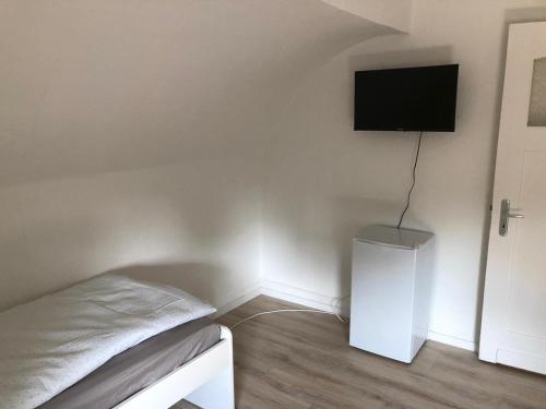 a bedroom with a bed and a flat screen tv on the wall at Haus mit 9 Einzelzimmern in Selm-Bork in Selm