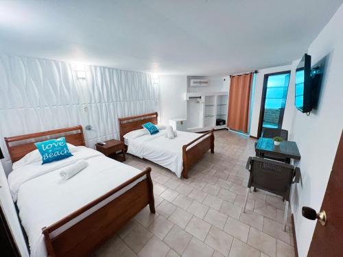 una camera d'albergo con due letti e una televisione di Apartamentos Turisticos In Di Morgan's Canon a San Andrés