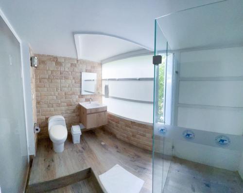 y baño con aseo y ducha acristalada. en Apartamentos Turisticos In Di Morgan's Canon, en San Andrés