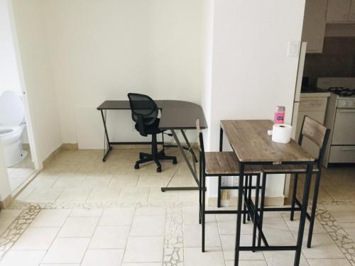 Zimmer mit 2 Tischen, einem Stuhl und einem Schreibtisch in der Unterkunft Stylish Montreal Apartment: Comfortable Stay in the Golden Square Mile in Montreal