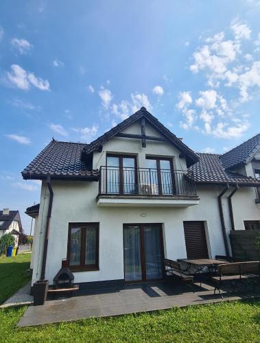 a white house with a balcony on top of it at Dom pod Wroclawiem19 in Domasław
