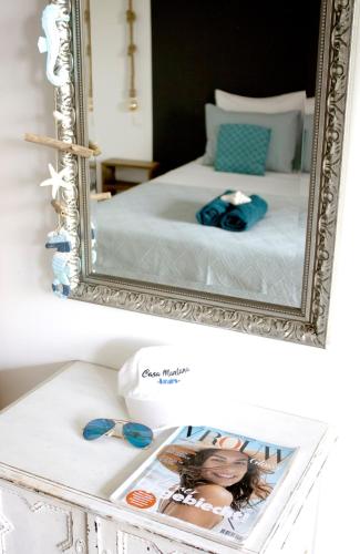 a mirror on a table with a bed and a magazine at Casa Mantana Bonaire in Kralendijk