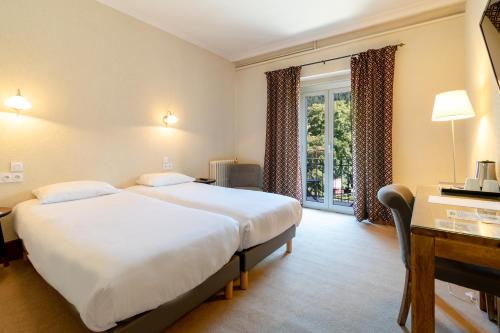 a hotel room with two beds and a window at Hôtel-Restaurant Le Lac in Malbuisson