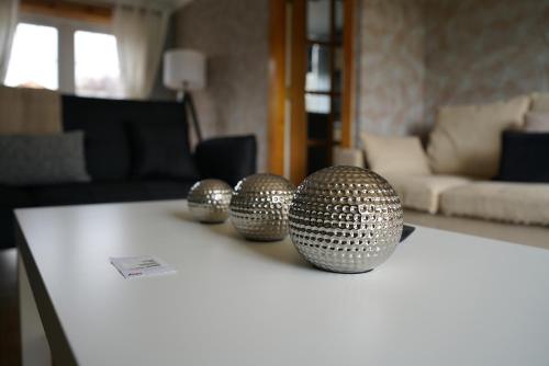 trois sphères argentées assises sur une table dans un salon dans l'établissement Ravenswood House, à Glenrothes