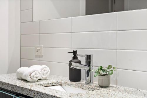 a bathroom counter with a sink and a faucet at Rooftop Pool 2BR Apt at Marvel Stadium with Free Parking in Melbourne