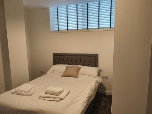 - une chambre avec un lit et 2 serviettes dans l'établissement Bayard Plaza 1 Bedroom Modern Spacious Apartment, à Peterborough