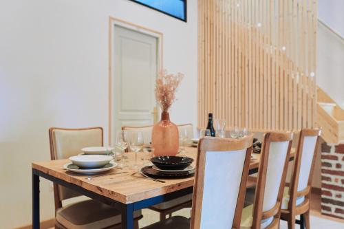 una mesa de madera con sillas y un jarrón. en Villa Bewick-Loft Architecte, en Saint-Valery-sur-Somme