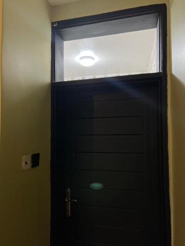 a black door in a room with a window at Fivas Residences in Arua