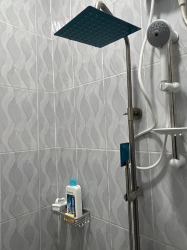 y baño con ducha y lámpara azul. en Fivas Residences, en Arua