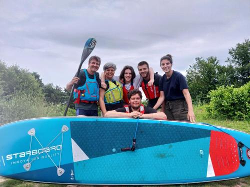 a group of people standing next to a surfboard at VillaEnzo - ELEGANT HERENHUIS - 14P - 6SLPK - SAUNA - INFRAR CABINE - OFYR BBQ - 15MIN Maastricht in Zussen