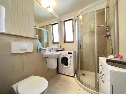ein Badezimmer mit einem Waschbecken und einer Waschmaschine in der Unterkunft Zdrojowa Sun Apartment in Świnoujście