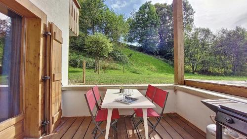 - une table et des chaises sur une terrasse couverte avec une fenêtre dans l'établissement Lucie, à Morzine