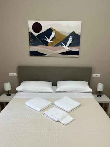 a bed with two pillows and two birds on it at B&B Casa Doria in Valmontone