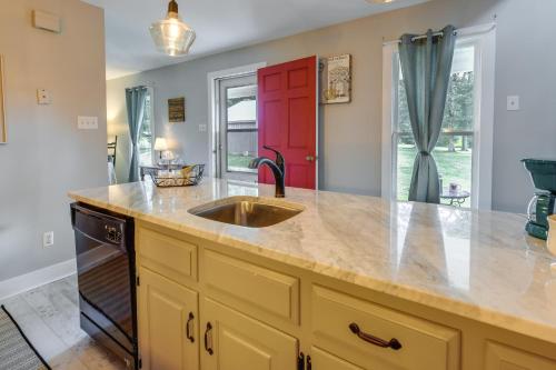 cocina con fregadero y puerta roja en Tranquil Cottage in Virginia Countryside with Pond!, en Midlothian