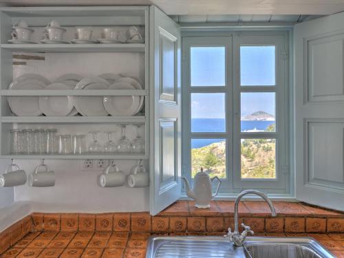 a kitchen with a window and a sink and a counter top at Eirini Luxury Hotel Villas in Grikos