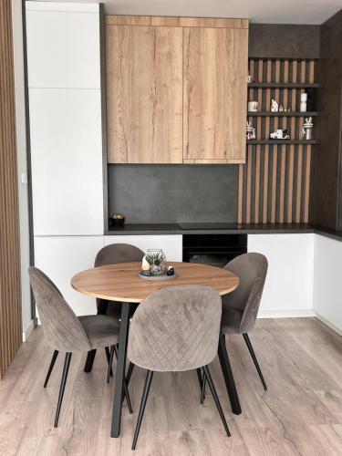 een eetkamer met een houten tafel en stoelen bij Bright & Modern 3 Room Apartment with All Amenities and Underground parking in Timişoara