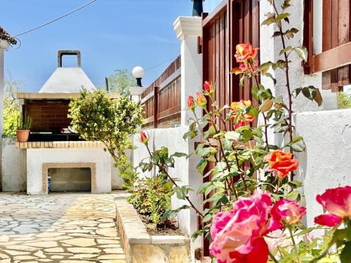 a courtyard with a fireplace and flowers at Sidari Beach Villa with private pool by DadoVillas in Agios Ioannis