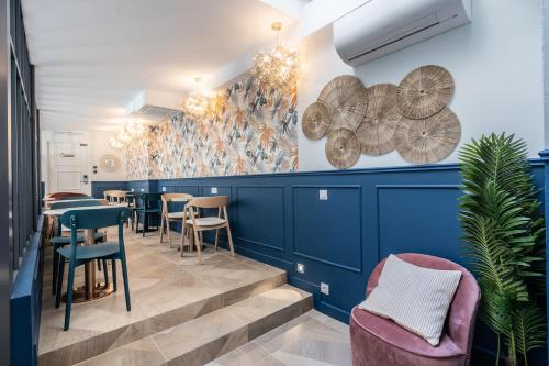 a restaurant with blue walls and tables and chairs at District Nation in Paris