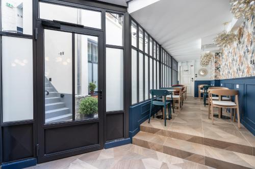 a restaurant with tables and chairs and windows at District Nation in Paris
