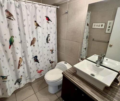 a bathroom with a shower curtain with birds on it at Casa Oasis en Providencia in Santiago