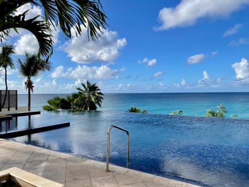 a swimming pool with a view of the ocean at Beachfront luxury 2br condo in Lowlands