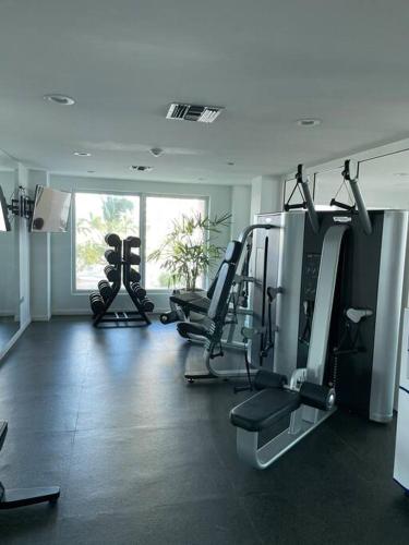 a gym with several tread machines in a room at Beachfront luxury 2br condo in Lowlands