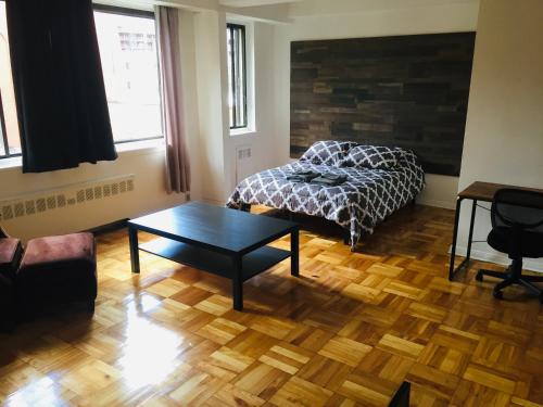 a bedroom with a bed and a table in it at Stylish Montreal Apartment: Comfortable Stay in the Golden Square Mile in Montreal
