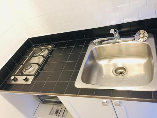 a sink in a kitchen next to a stove at Stylish Montreal Apartment: Comfortable Stay in the Golden Square Mile in Montreal
