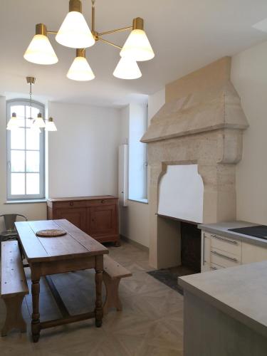 - une cuisine avec une table et une cheminée en pierre dans l'établissement Maison La Demi-Lune, à Boulleret