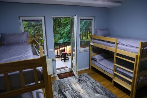 a bedroom with two bunk beds and a balcony at City Park Hostel in Prishtinë